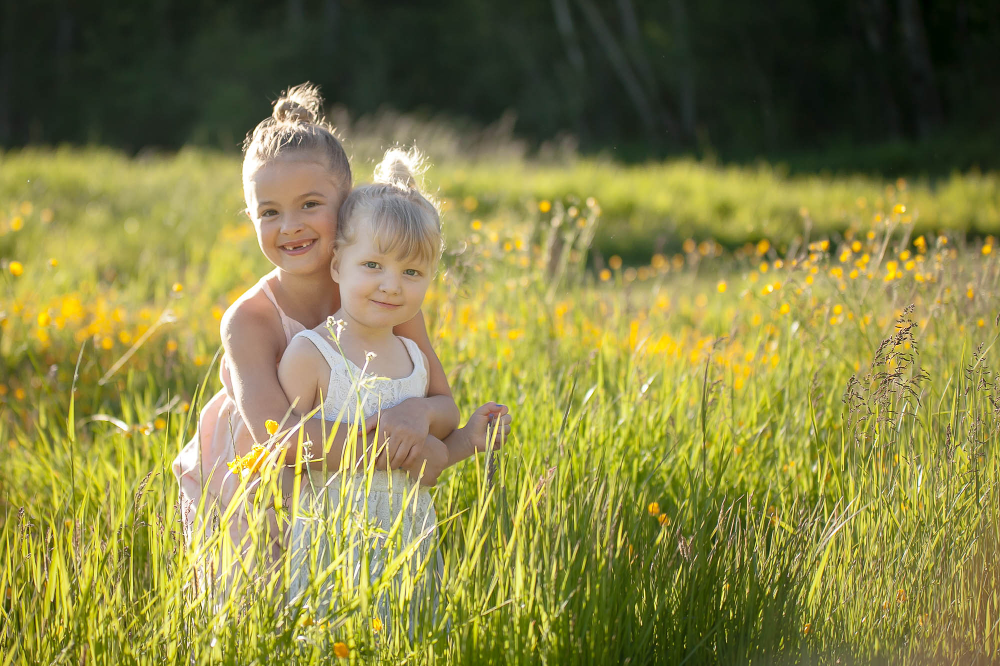 Sisters hugging in a field during maternity session in Langley. 